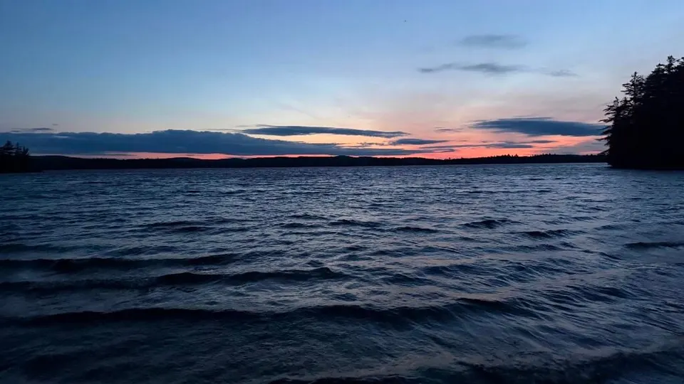 Sunset glowing pink and blue over a dark lake