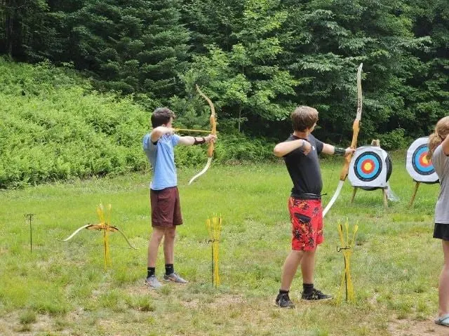 Scouts drawing their bows on the archery range