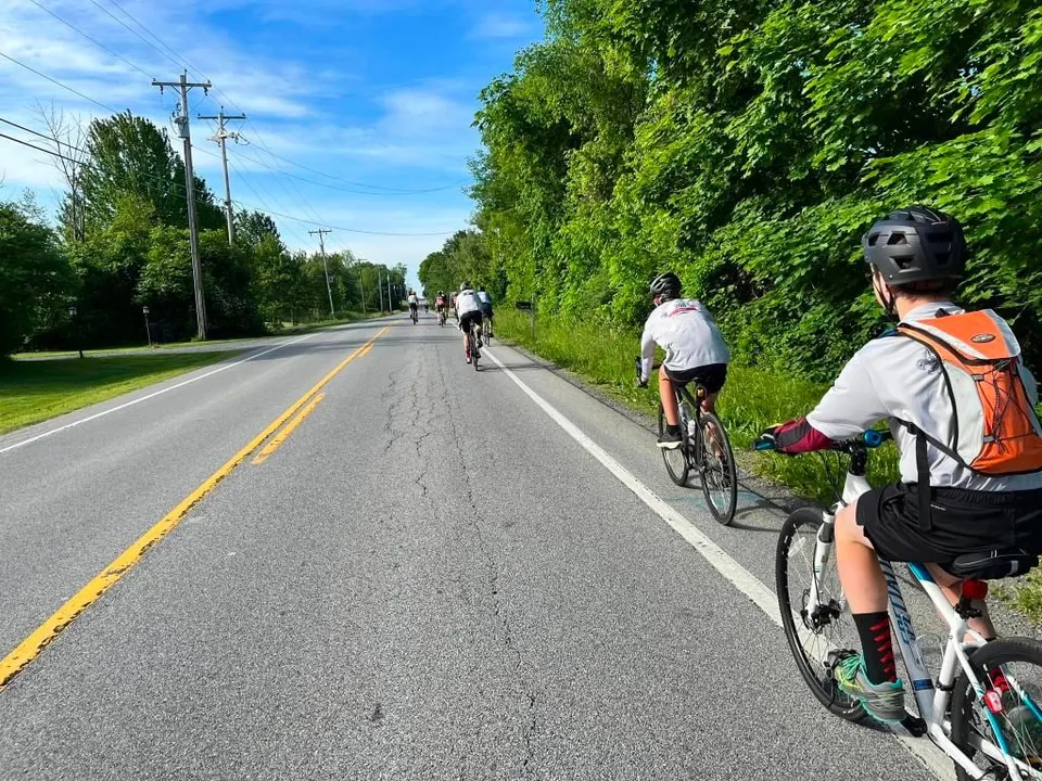 A line of cyclists on a country road during the Tour de Cure