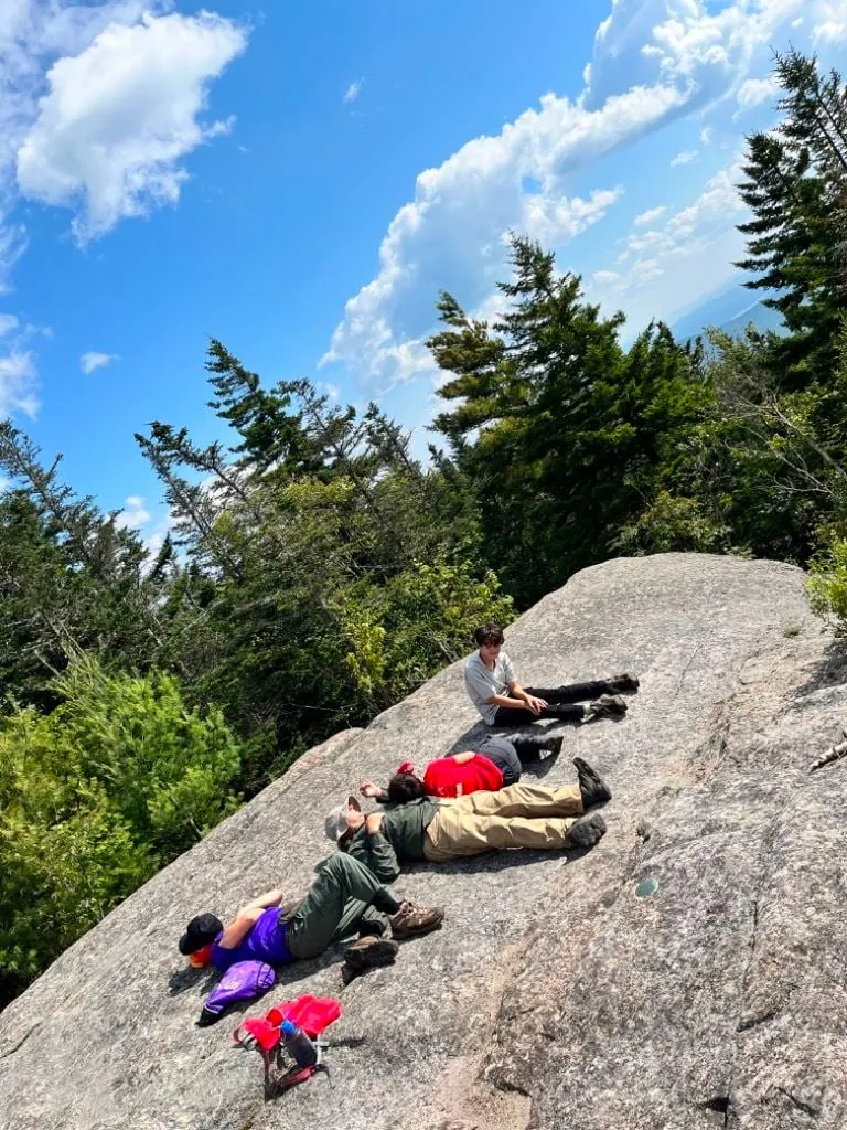 Scouts stretched out on a sun-warmed granite summit after the climb