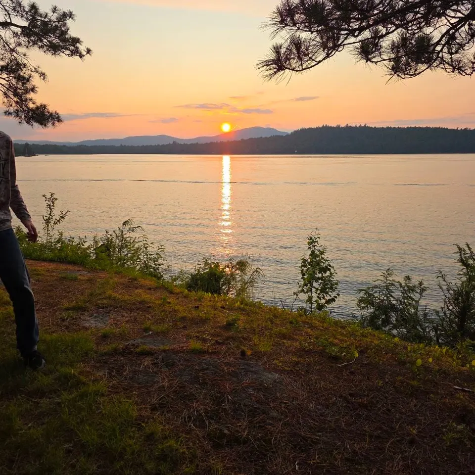 The sun setting over Raquette Lake and the hills beyond