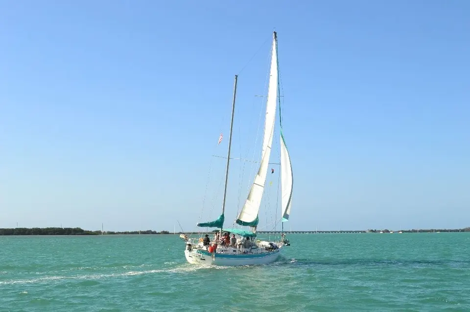 A sailboat under full sail on turquoise water off the Florida Keys