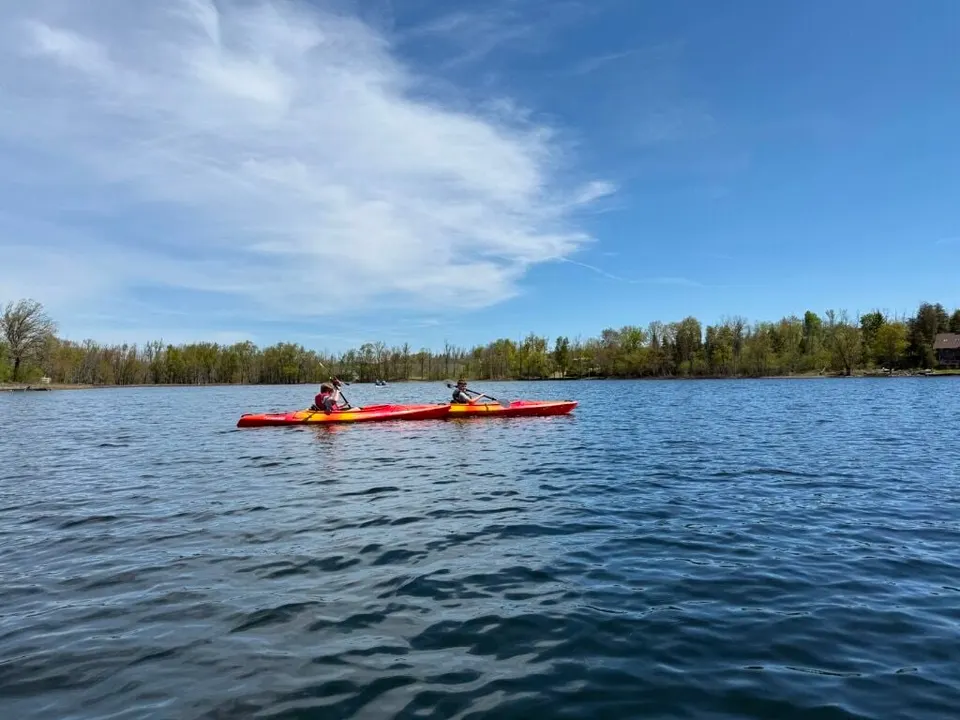 A kayak out on open water under a big blue sky