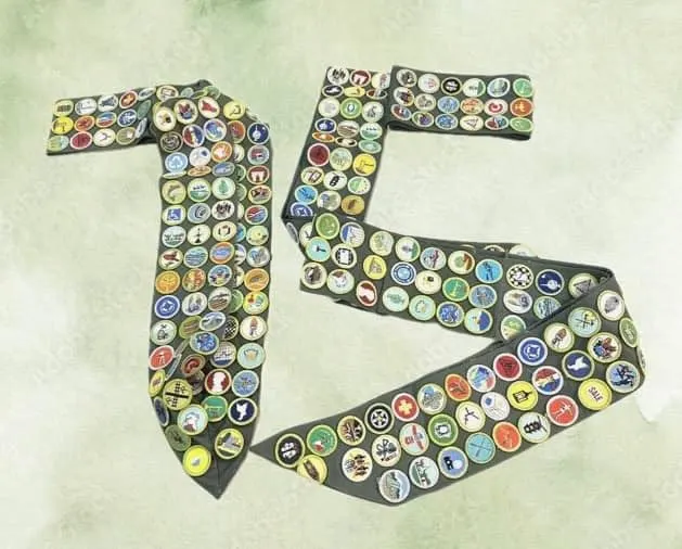 Merit badge sashes arranged on a table to spell out 75