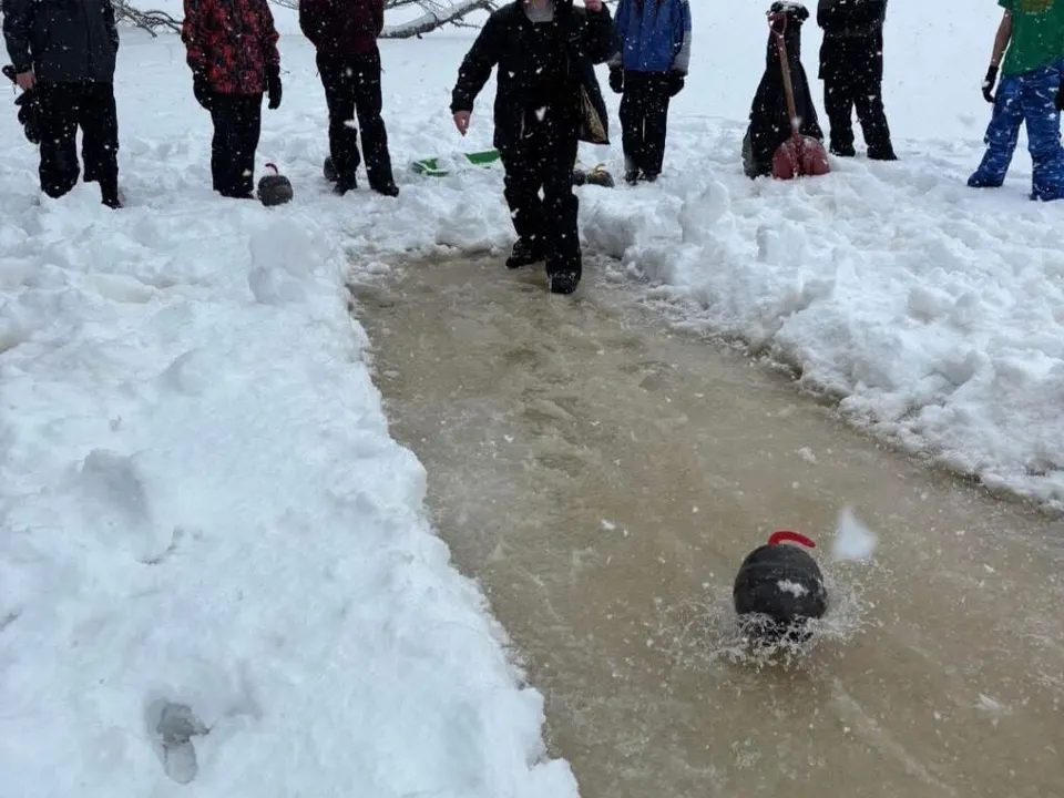 Scouts gathered around a snowy sled run at winter camp