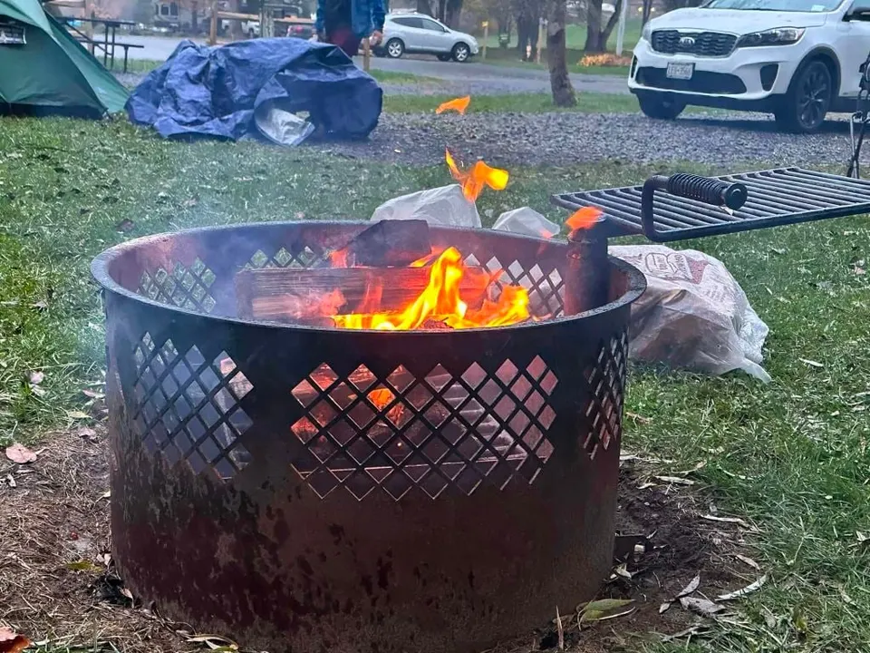 A campfire crackling in a fire pit at a fall campout